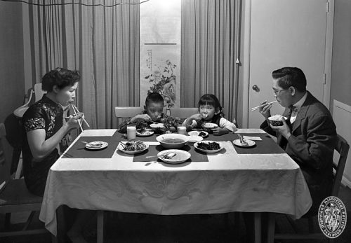 Unidentified Chinese American Family at Dinner. March, 1958. Photograph by A. Aubrey Bodine.